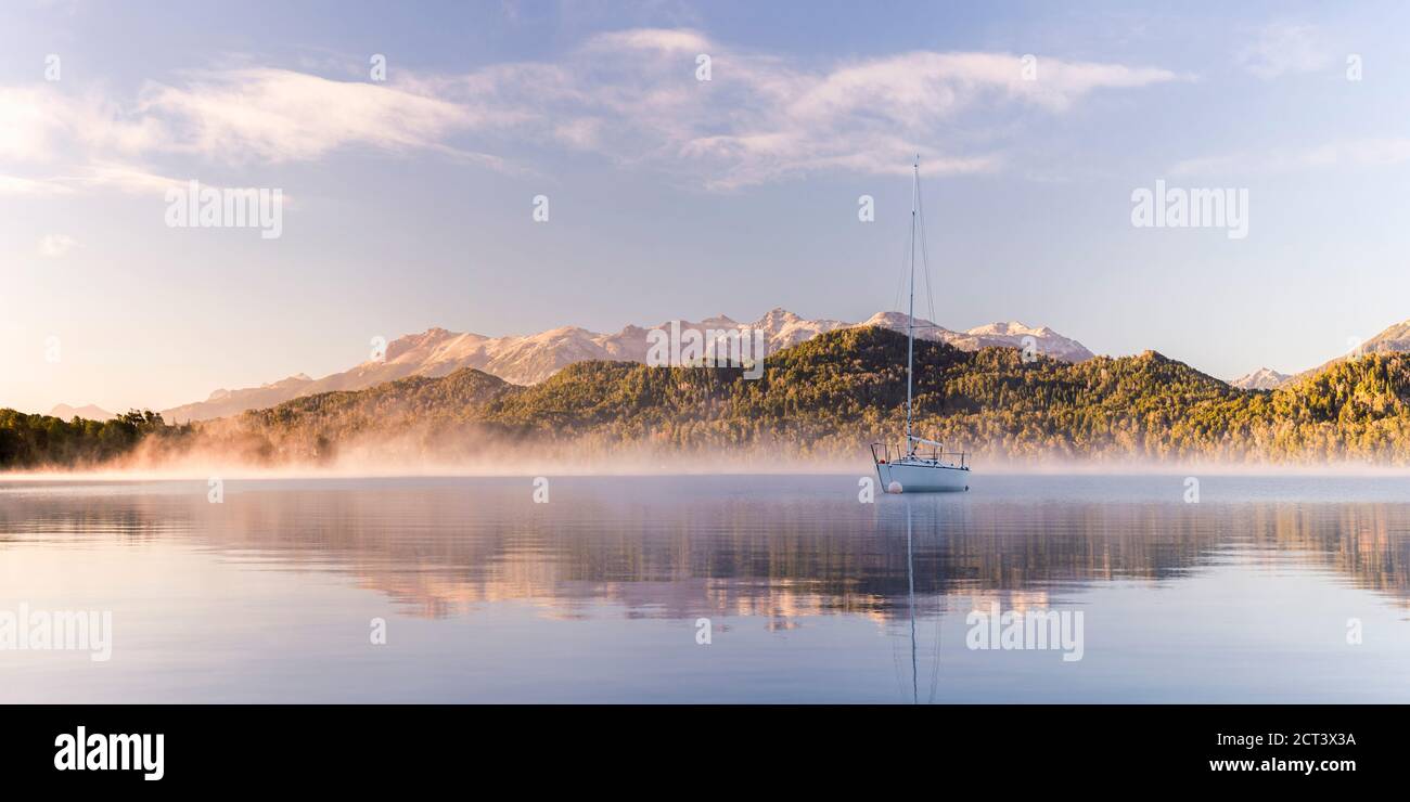 Sailing boat on misty Lake Nahuel Huapi at sunrise, Villa la Angostura, Neuquen, Patagonia, Argentina, South America, background with copy space Stock Photo