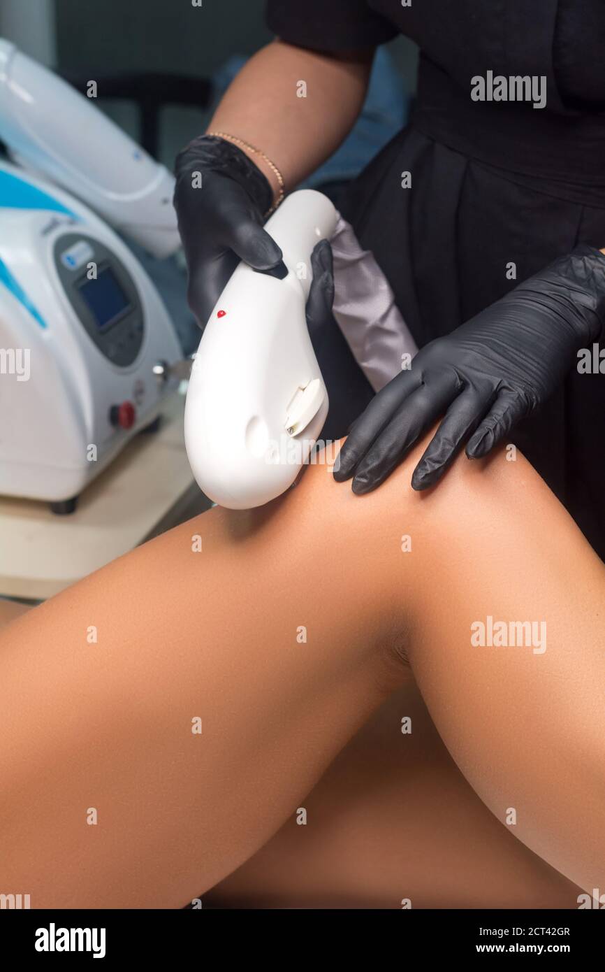 Beautician makes Elos epilation. Leg hair removal procedure Stock Photo