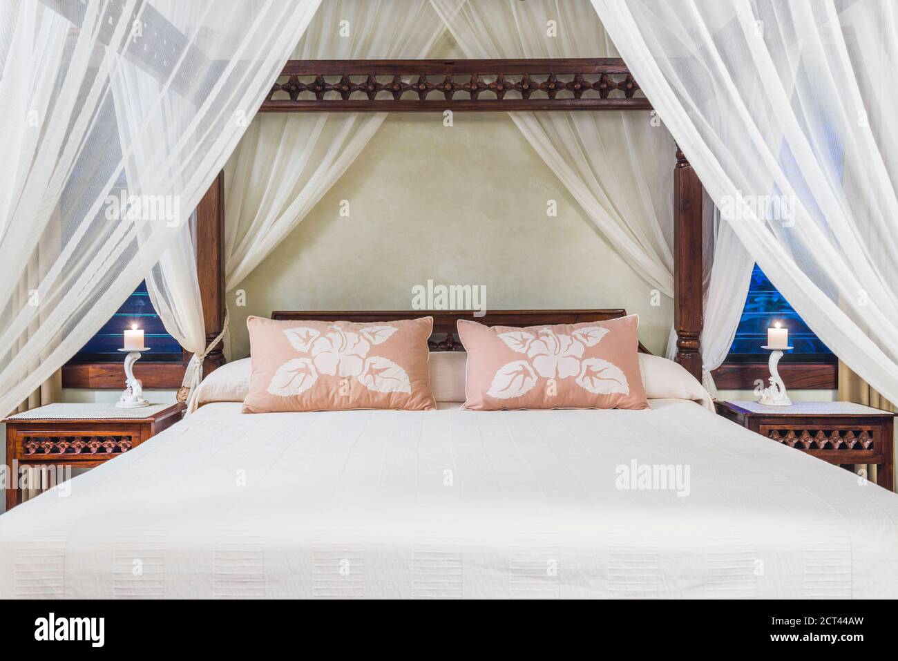 Luxury accommodation hotel bedroom details of a four poster bed with cushions Stock Photo