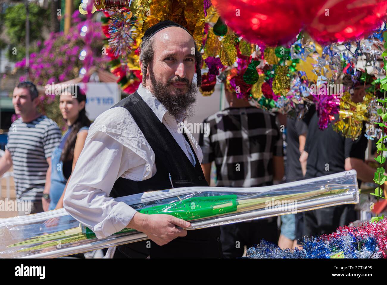 TEL AVIV, ISRAEL – OCTOBER 4, 2017: Jewish man wearing kippah and holding a Palm branch on Sukkot's four species festival. Sukkah decorations Stock Photo