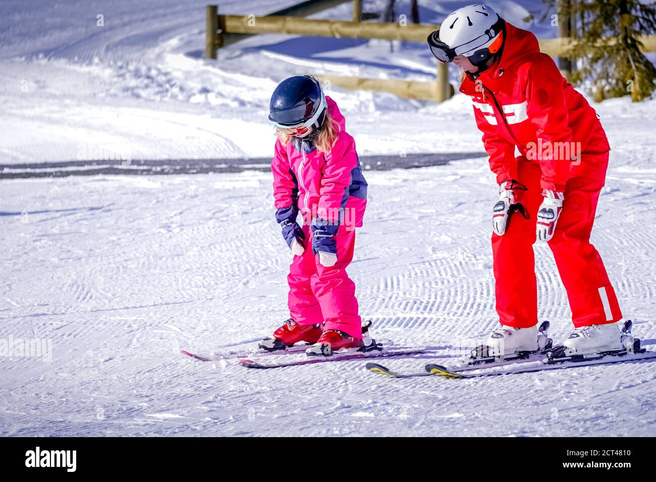 L'Alpe D'Huez, France 02.01.2019 Professional ski instructor is teaching a child to ski on a sunny day on a mountain slope resort. Family and children active vacation. Stock Photo