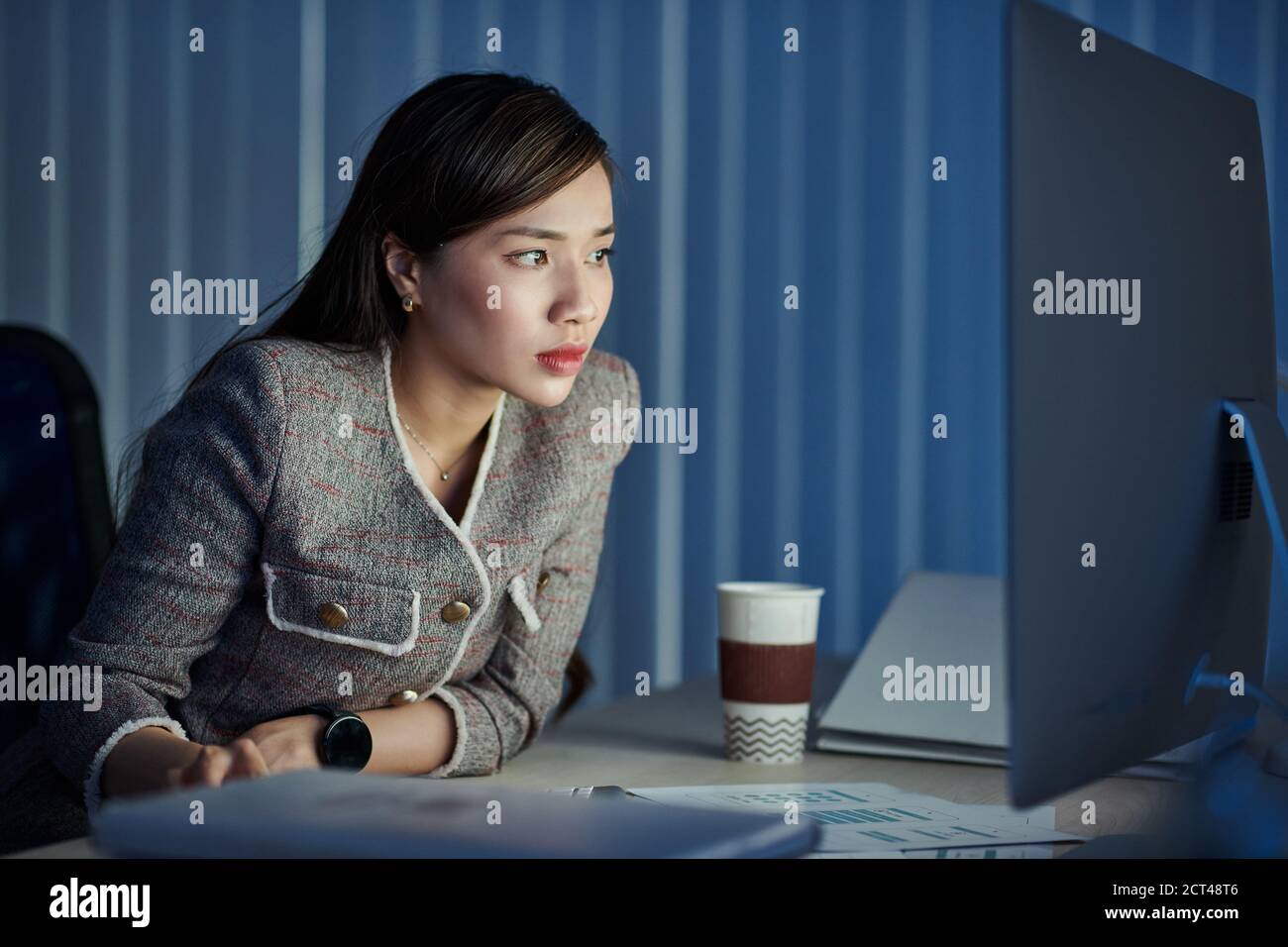 Business lady looking at glowing screen Stock Photo