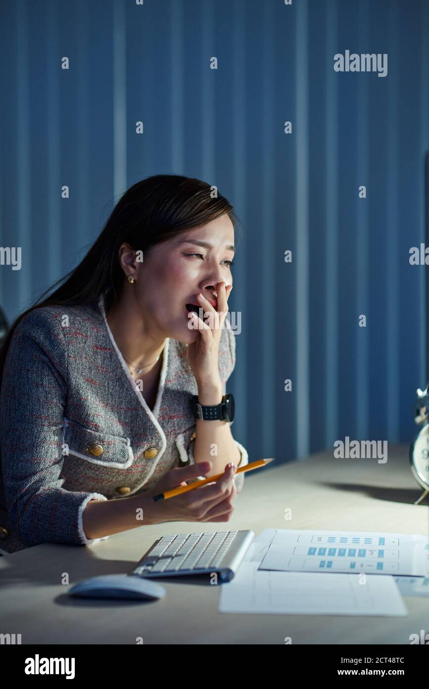 Yawning woman working in office Stock Photo