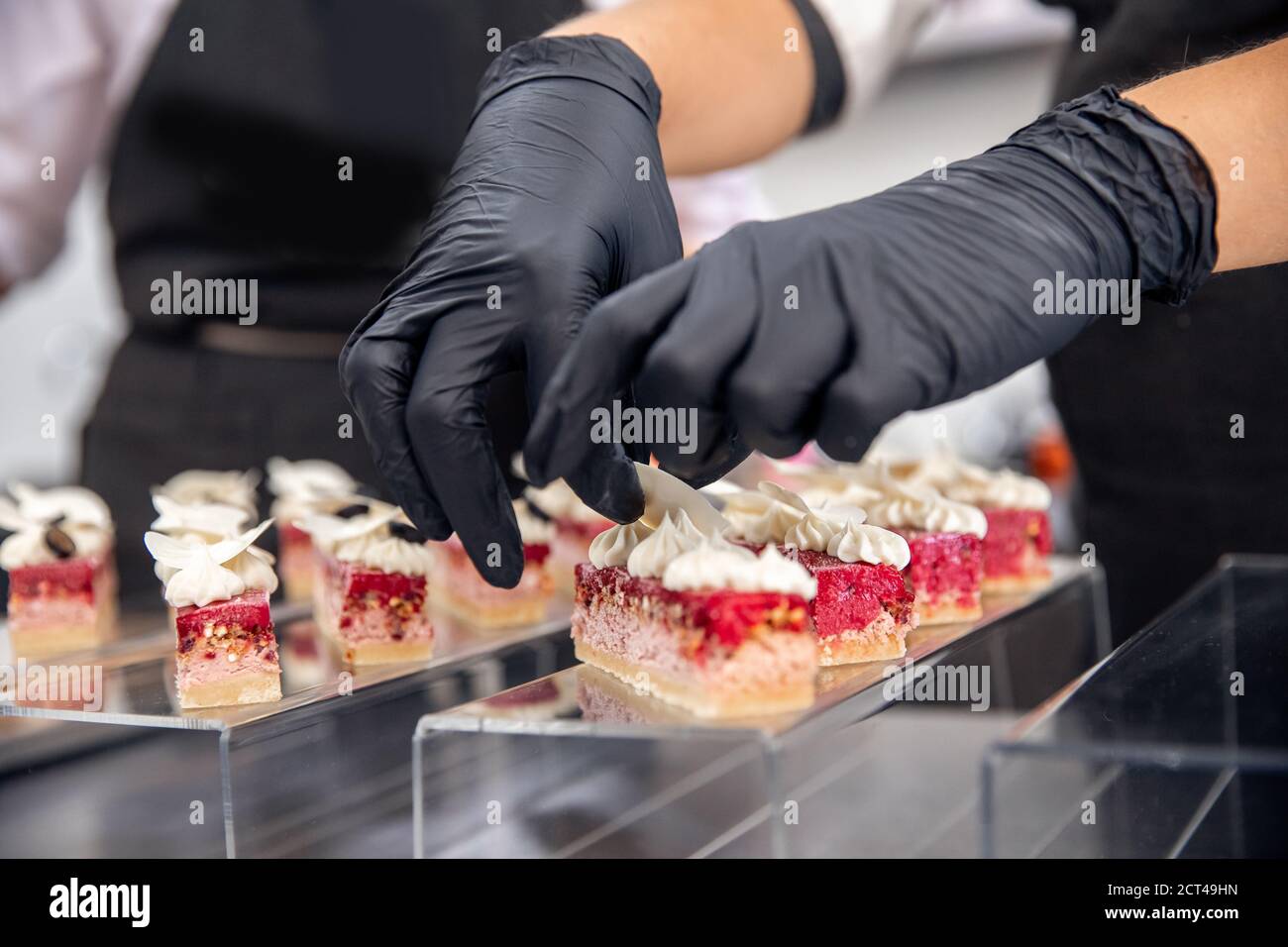 Chef hand in patisserie restaurant prepares cakes and decorates with chocolate icing Stock Photo