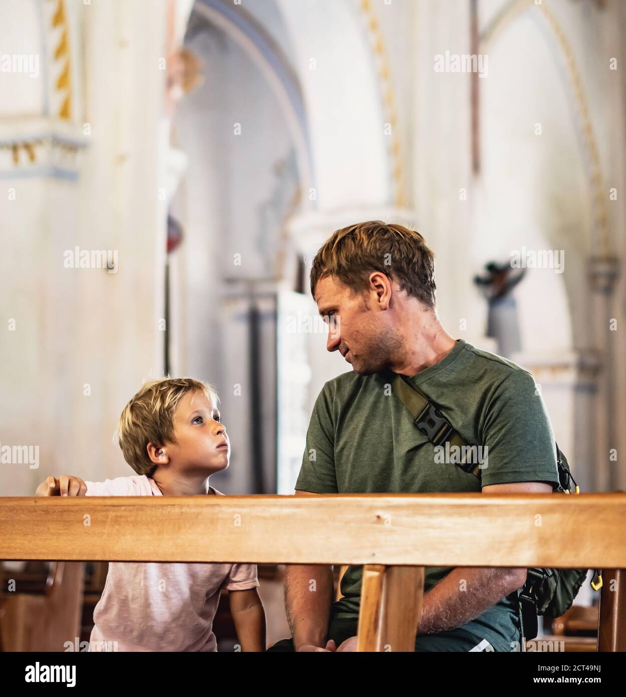 Christian dad tells his son Bible stories about Jesus sitting in kirk ...