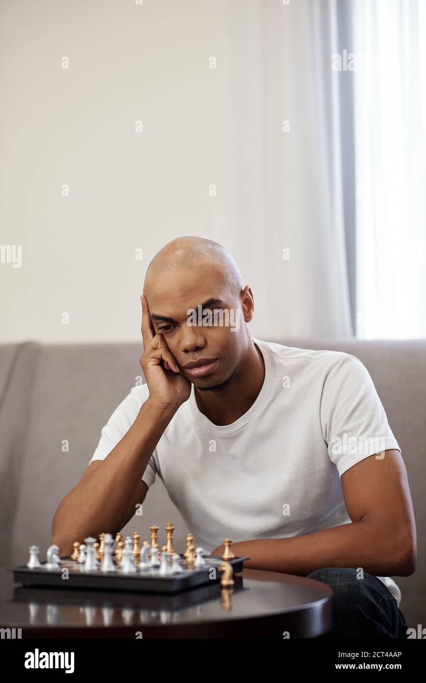 Man looking at chess board Stock Photo