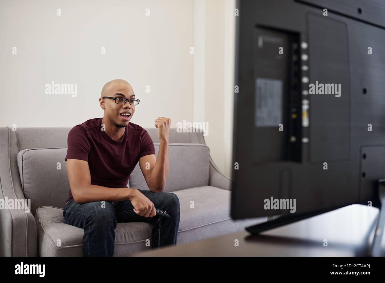 Man watching competition on tv Stock Photo