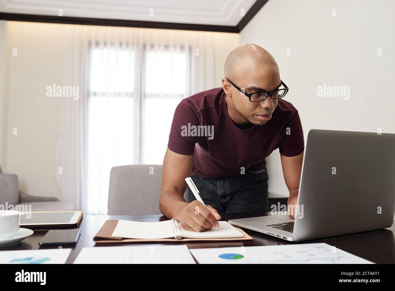 Businessman checking reports on laptop Stock Photo