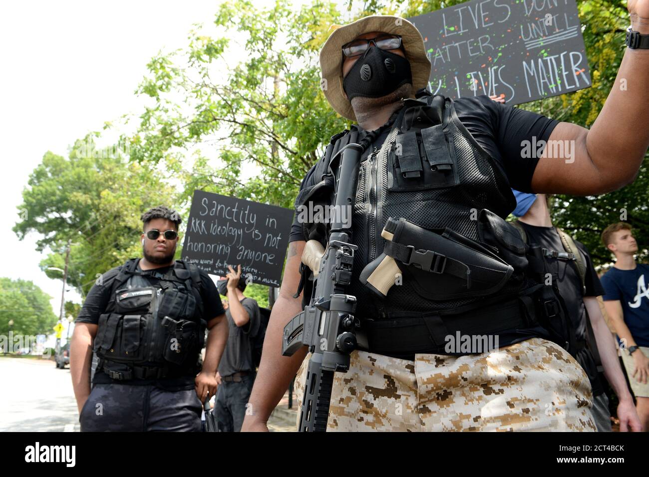 LOCK & LOADED: June 6, 2020, Kennesaw, Georgia, USA: Armed members of 'My Brother's Keeper' organization, carrying loaded AK-47s and handguns, brandishing signs saying: SANCTITY IN KKK IDEOLOGY IS NOT HONORING ANYONE and LIVES WON'T MATTER UNTIL ALL LIVES MATTER. One of the heavily armed men stated: 'We want to make sure everyone stays safe'. Group of angry demonstrators gathered outside Wildman's Civil War Surplus on Main Street. Mr. Myers owns the store and the building that has housed his controversial shop for more than 40 years. The protesters urged city officials for closure of the store Stock Photo