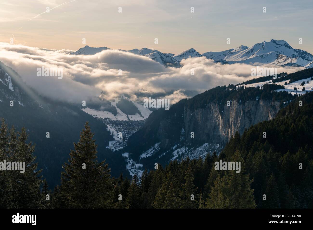 Dramatic snowy winter mountain landscape with low misty clouds and forests at the ski resort of Morzine in the Alps Mountain Range of France, Europe Stock Photo