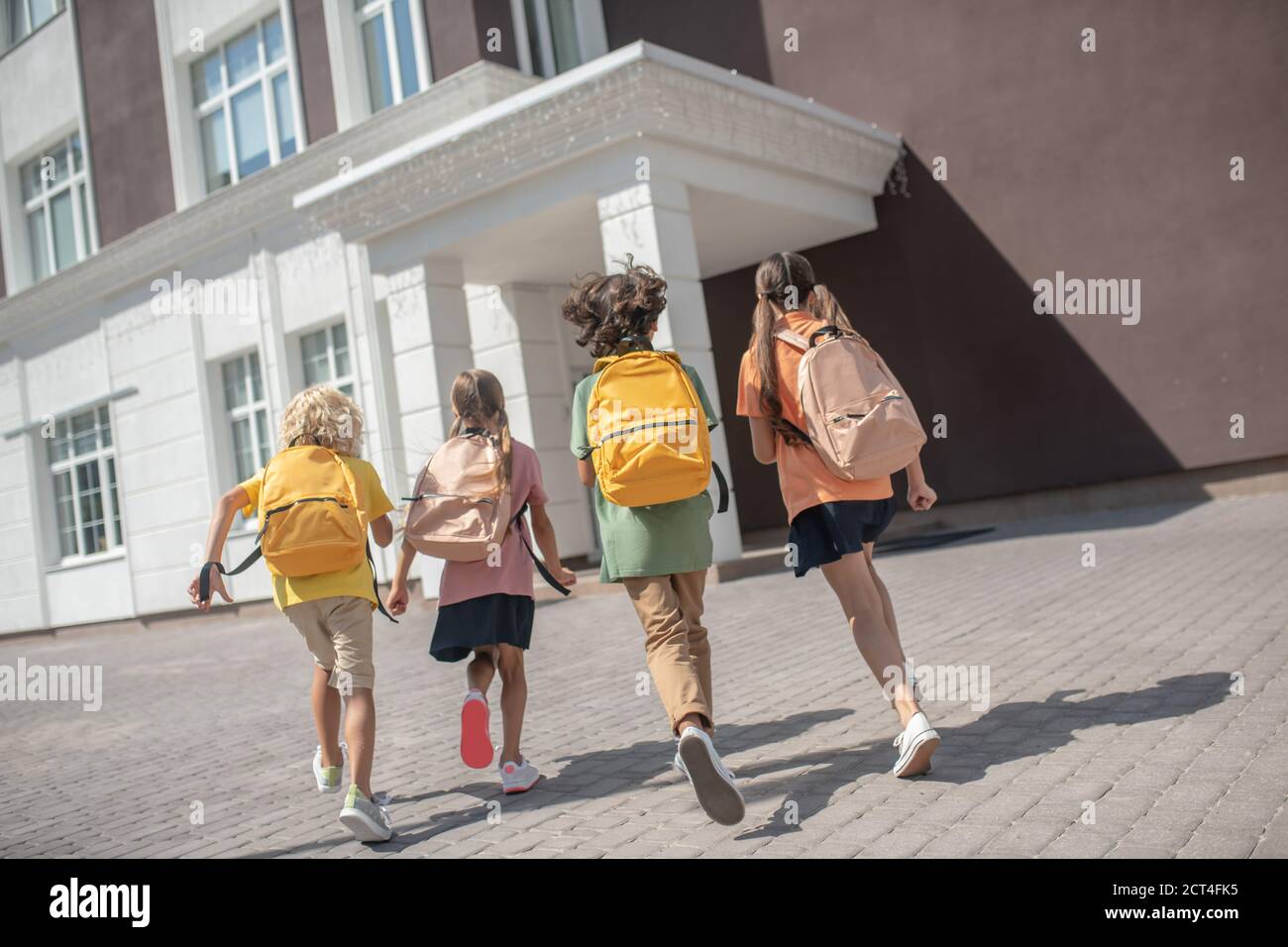 Children with backpacks on their way to the lessons Stock Photo - Alamy