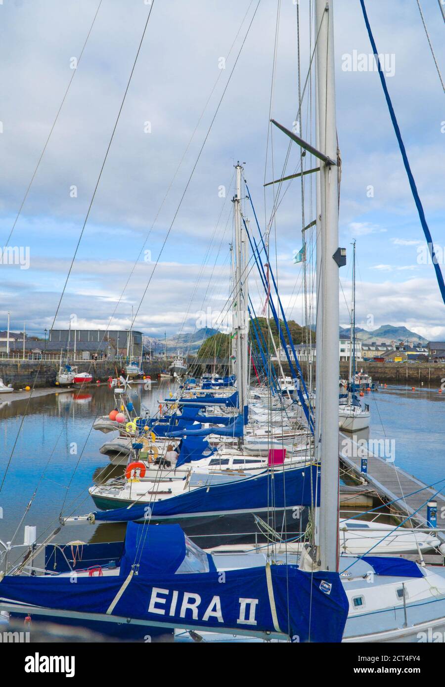 Boats moored up in Porthmadog harbour with Moelwyn Mountains in the distance, North Wales UK August 2020. Stock Photo