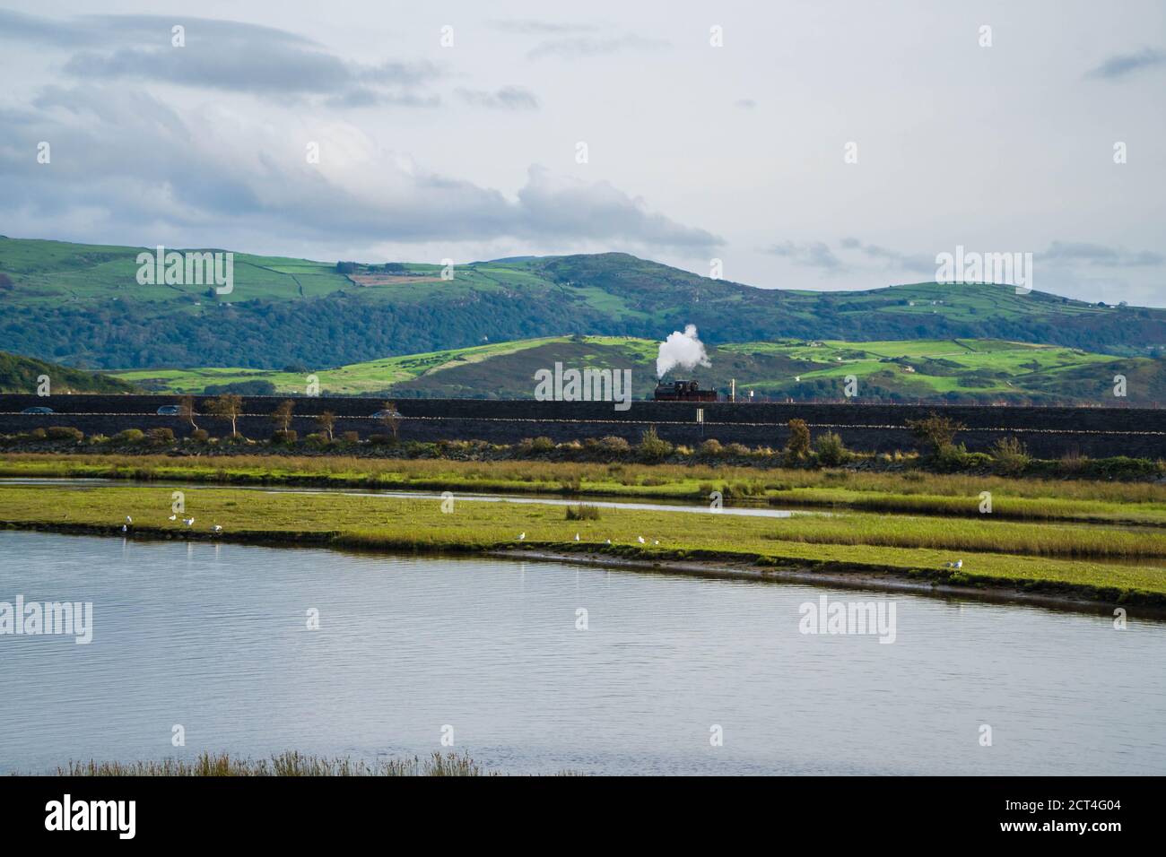 Ffestioiog and Welsh Highland Railway engine steaming along the Cob, Porthmadog North Wales UK. August 2020 Stock Photo