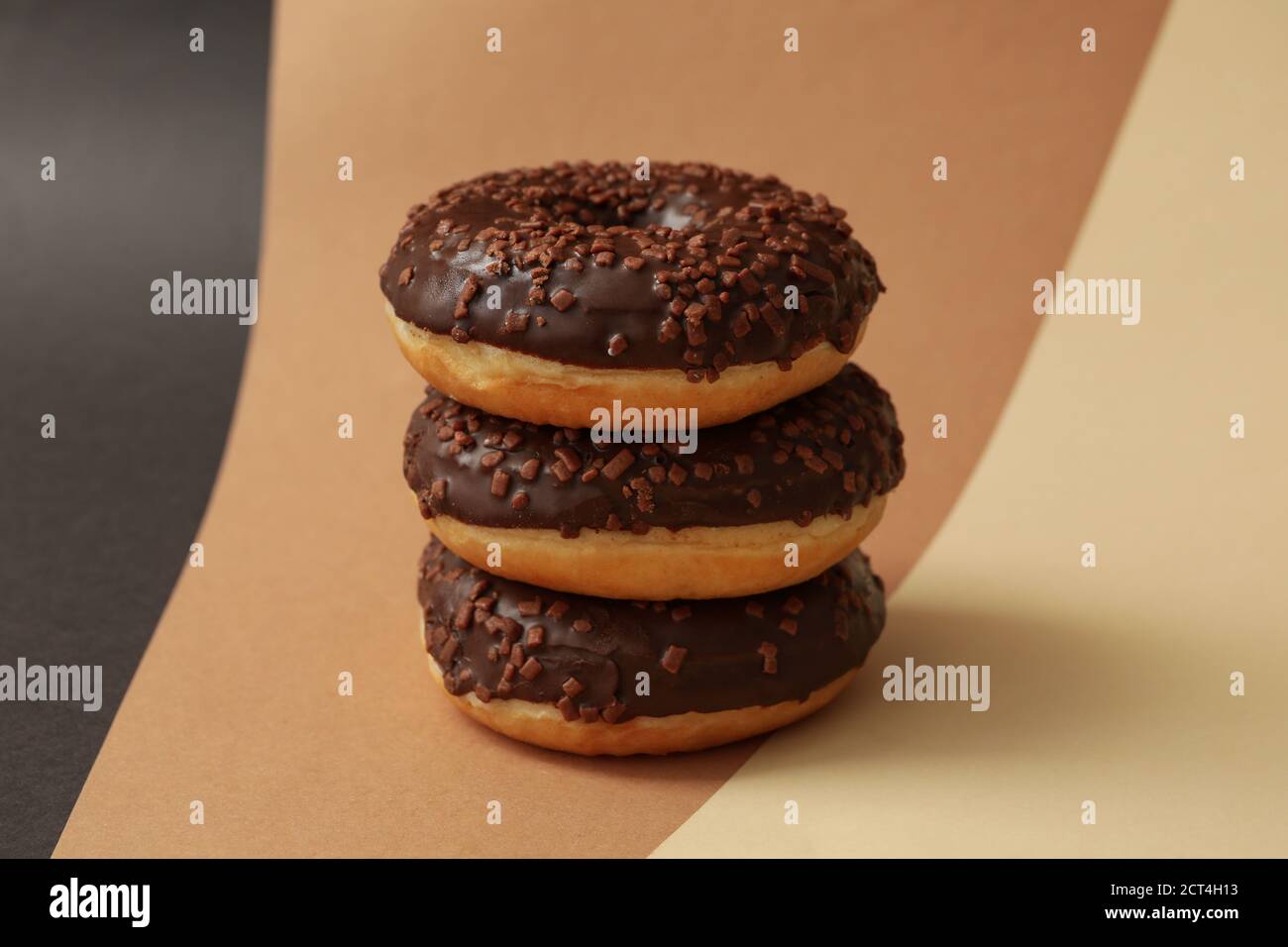 Tasty chocolate donuts on three tone background Stock Photo