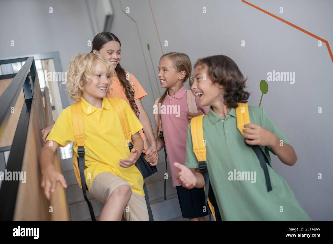 Boys and girls going downstairs and looking excited Stock Photo