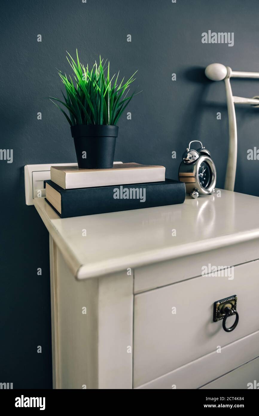Bedside table with books and plant Stock Photo