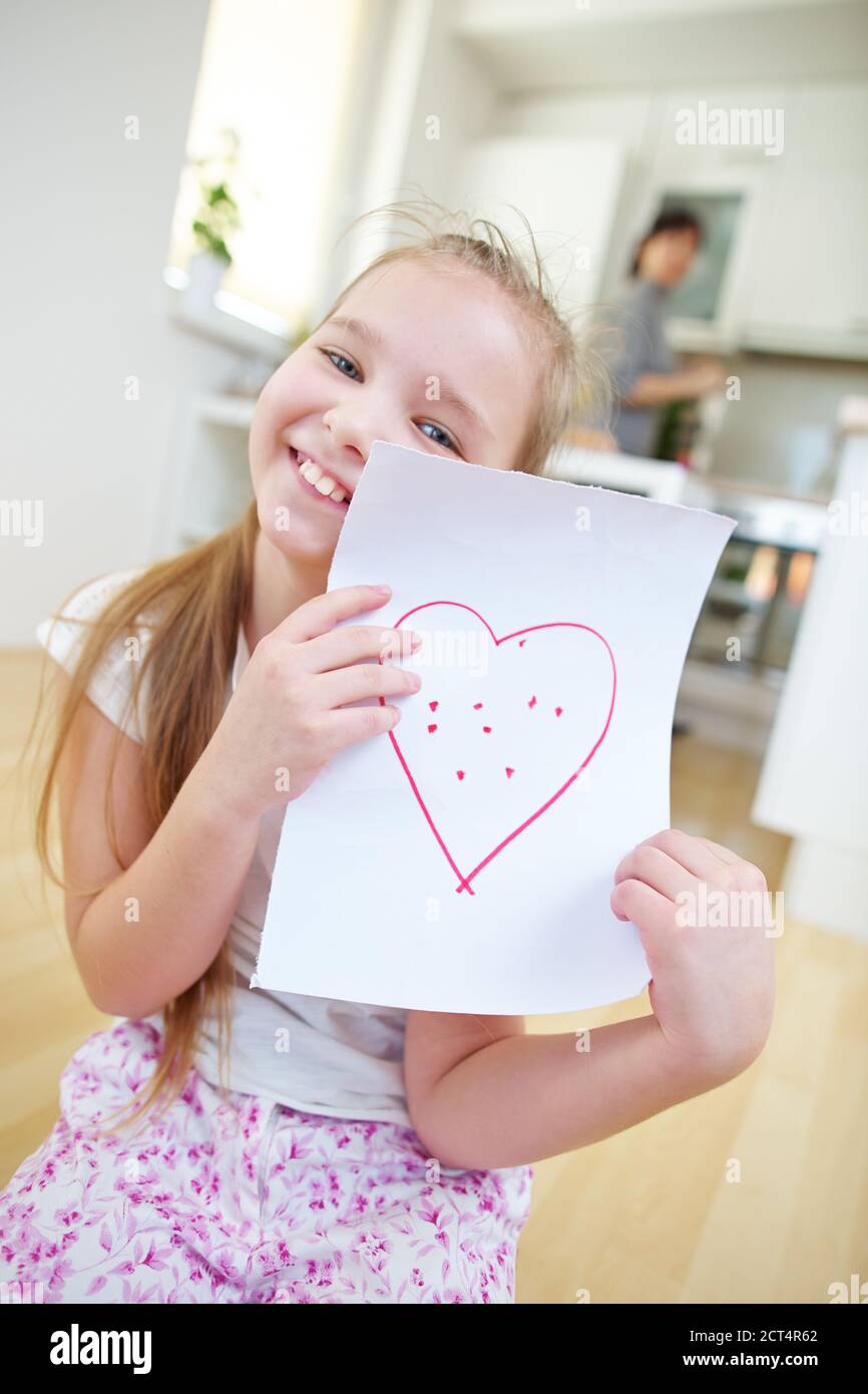 Happy girl shows a sheet of paper with a red heart Stock Photo - Alamy