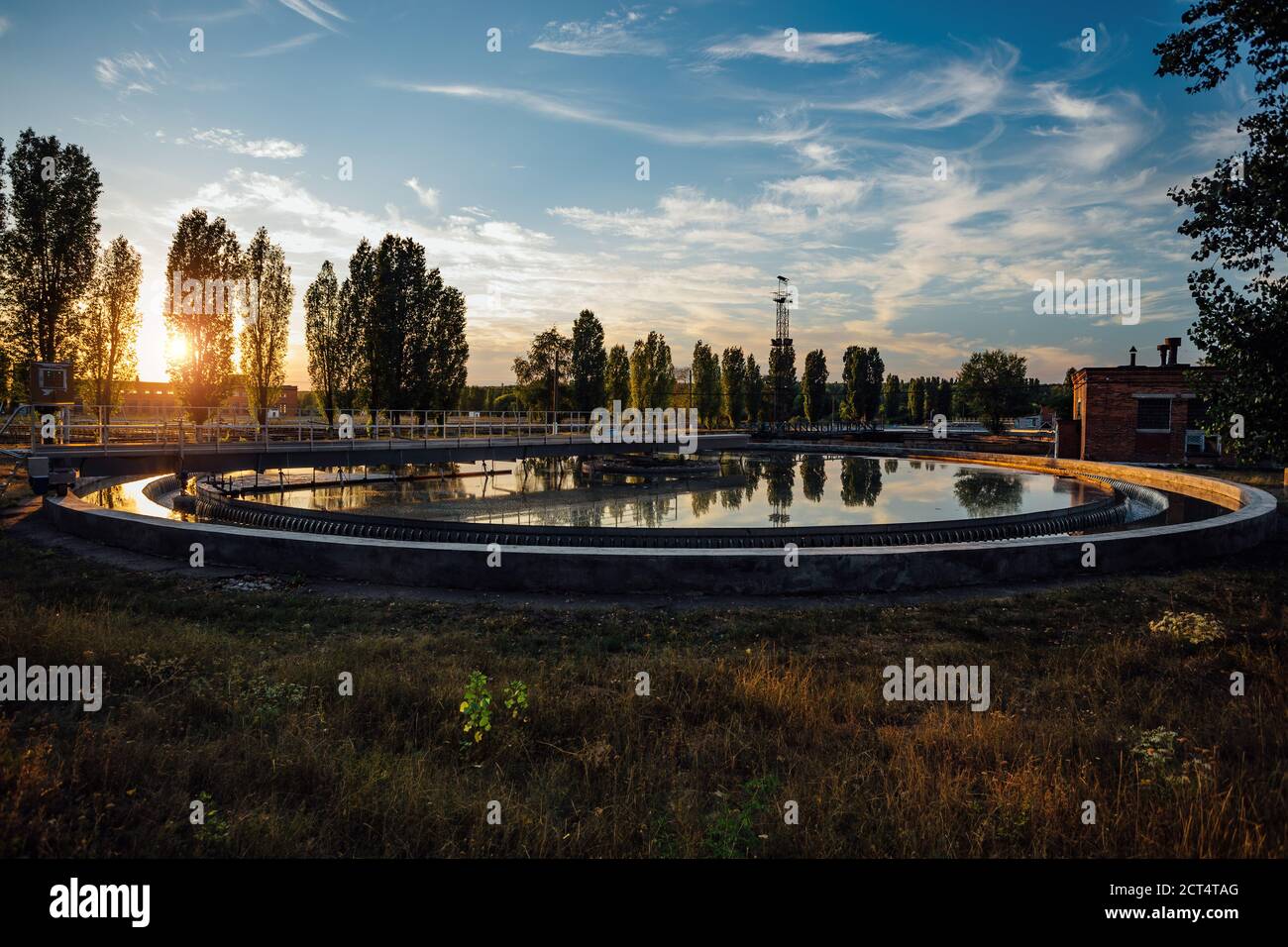 Modern sewage treatment plant. Round wastewater purification tank at sunset Stock Photo