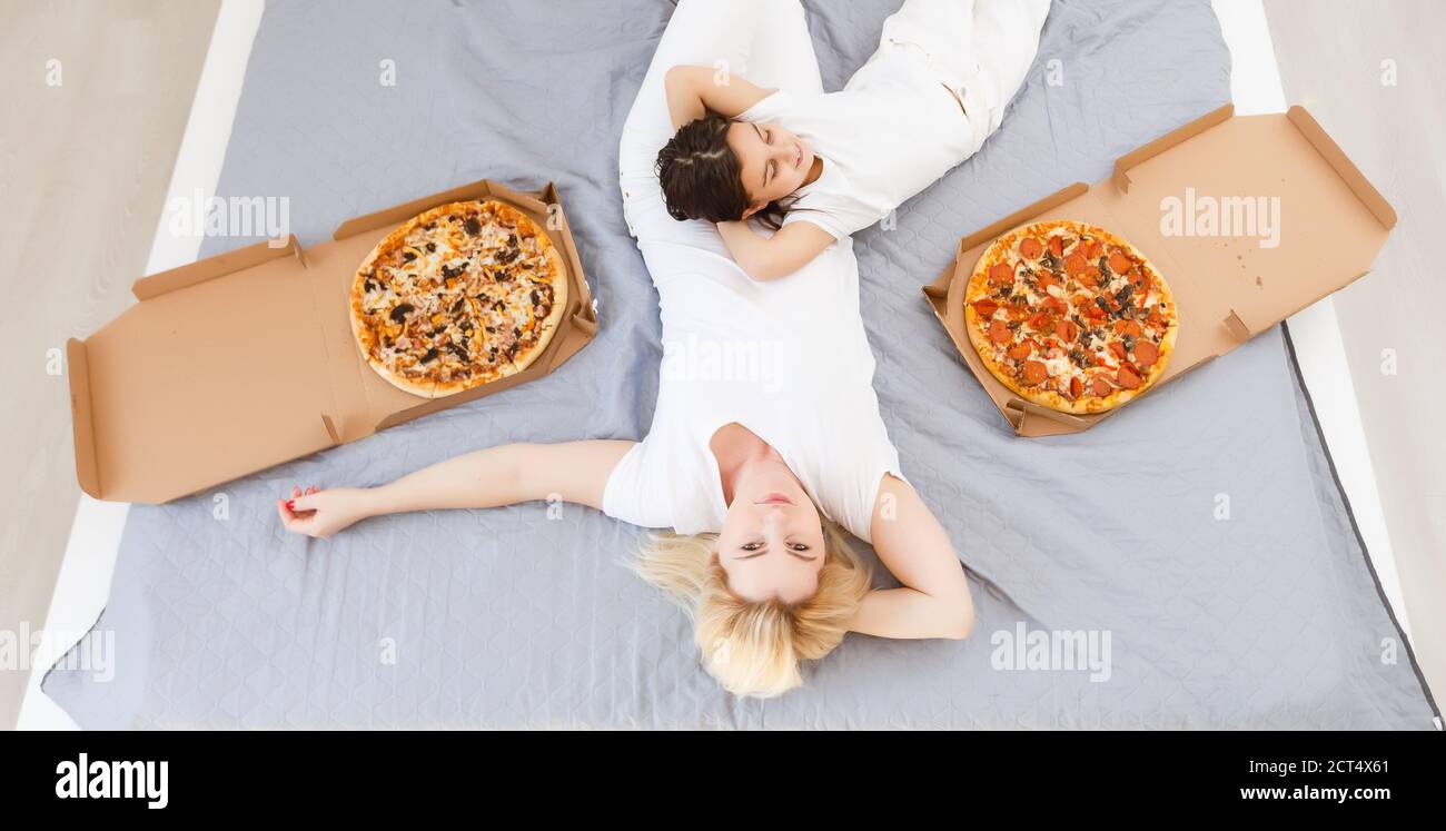 Mother and daughter eating pizza. relaxing at home Stock Photo