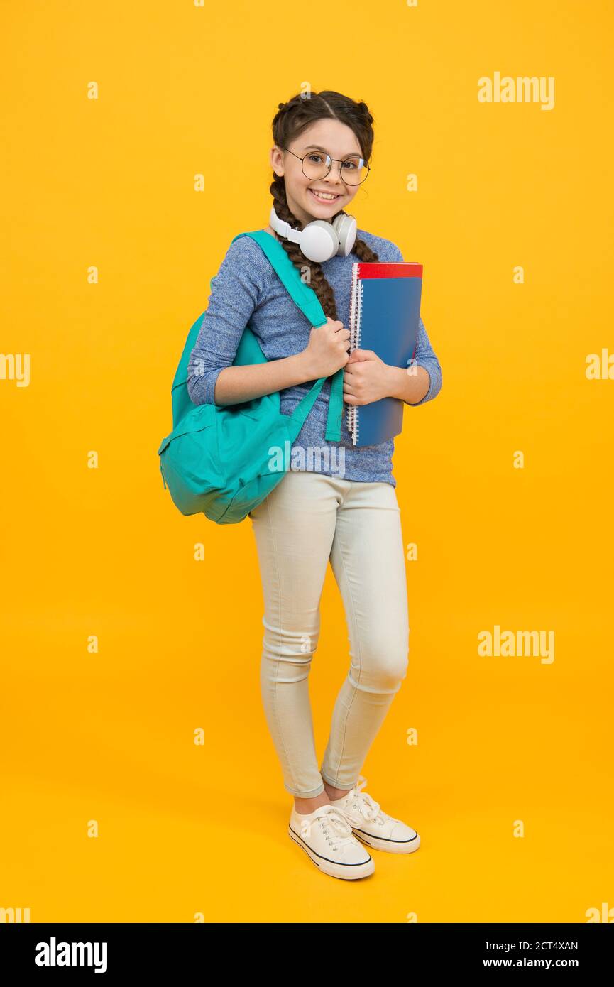 Modern student girl with backpack and school supplies yellow background ...
