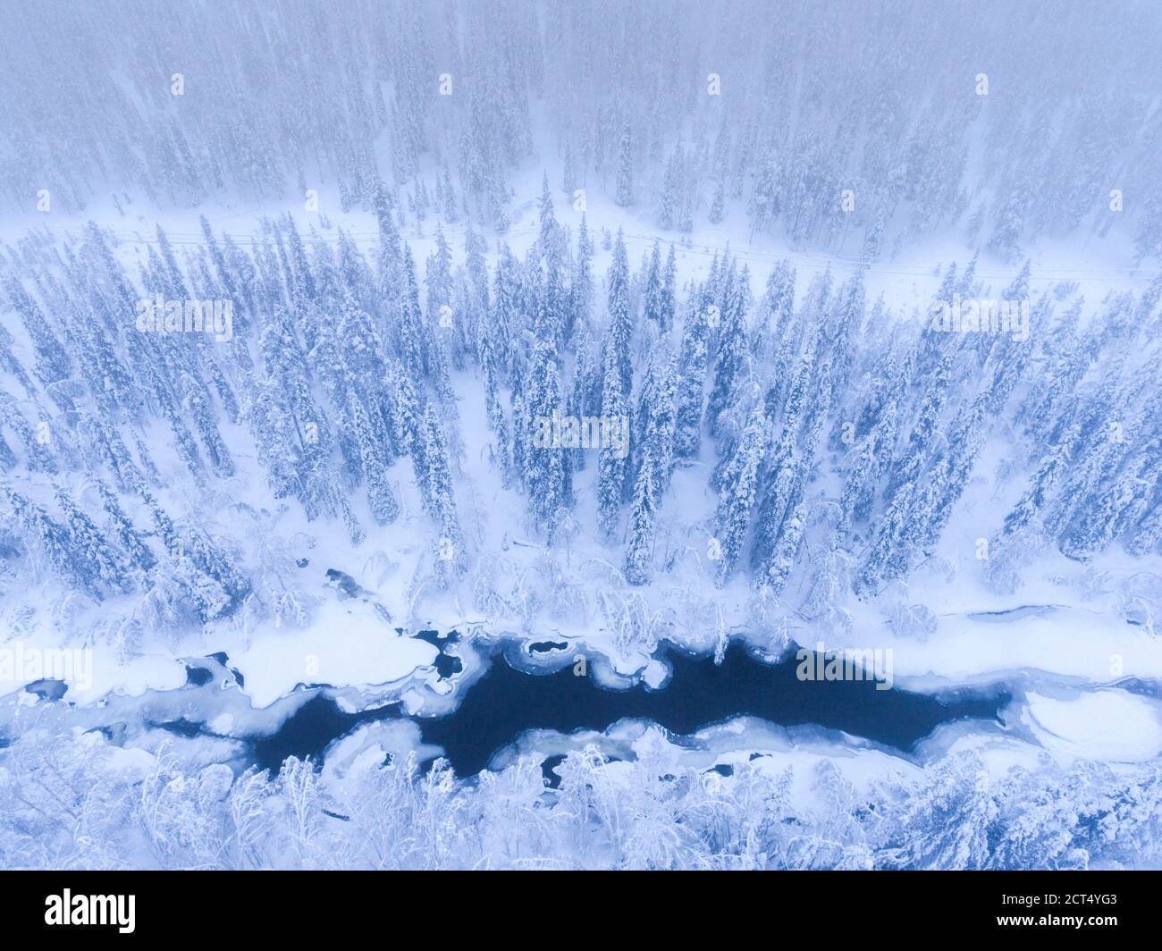 Aerial of frozen river and snow covered forest winter landscape showing amazing Lapland scenery in Scandinavia in Finland drone Stock Photo