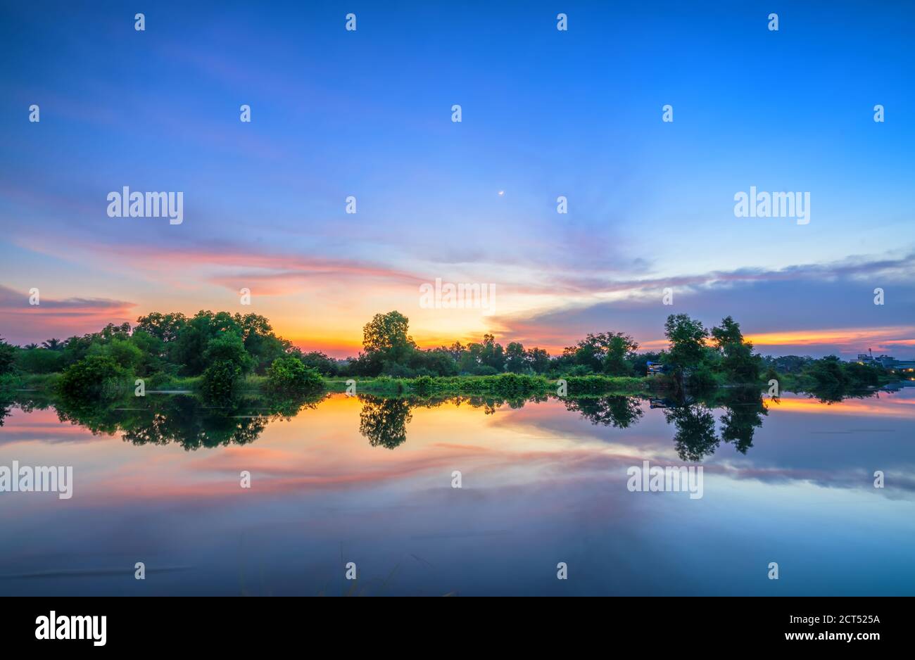 The sunset on the riverbank reflects the peaceful background in the countryside Stock Photo