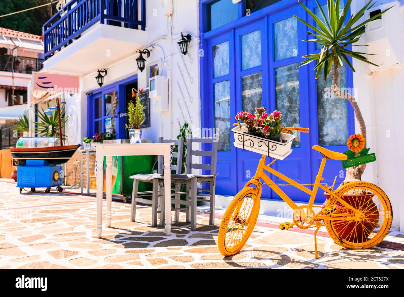 Greece street taverns decorated with flowers and old bicycle. Stock Photo