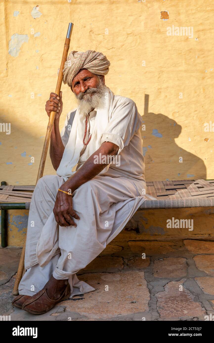 Elderly Indian man resting on a bed, Jaisalmer, Rajasthan, India Stock Photo