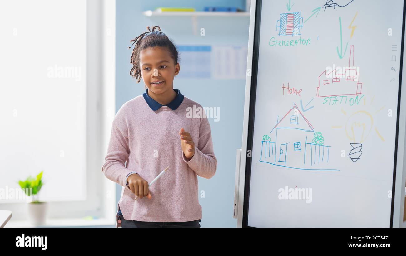 Elementary School Science Class: Portrait of Cute Girl Uses Interactive  Digital Whiteboard to Show to a Full Classroom how Renewable Energy Works  Stock Photo - Alamy