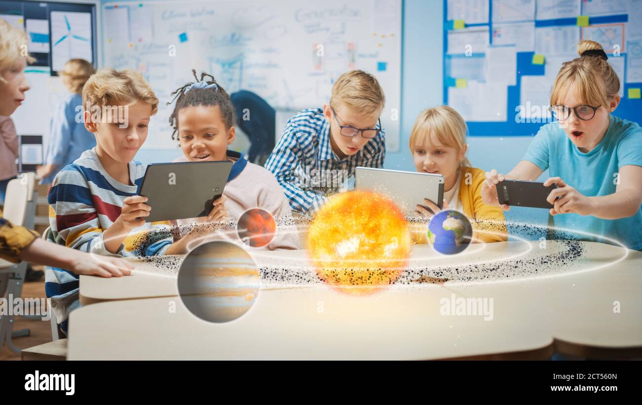 Group of School Children in Science Class Use Digital Tablet Computers with Augmented Reality Software, Looking at Educational 3D Animation Of Solar Stock Photo