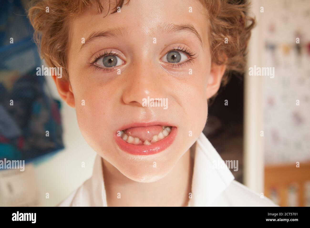 Five year old boy with a wobbly front tooth, Hampshire, England, United