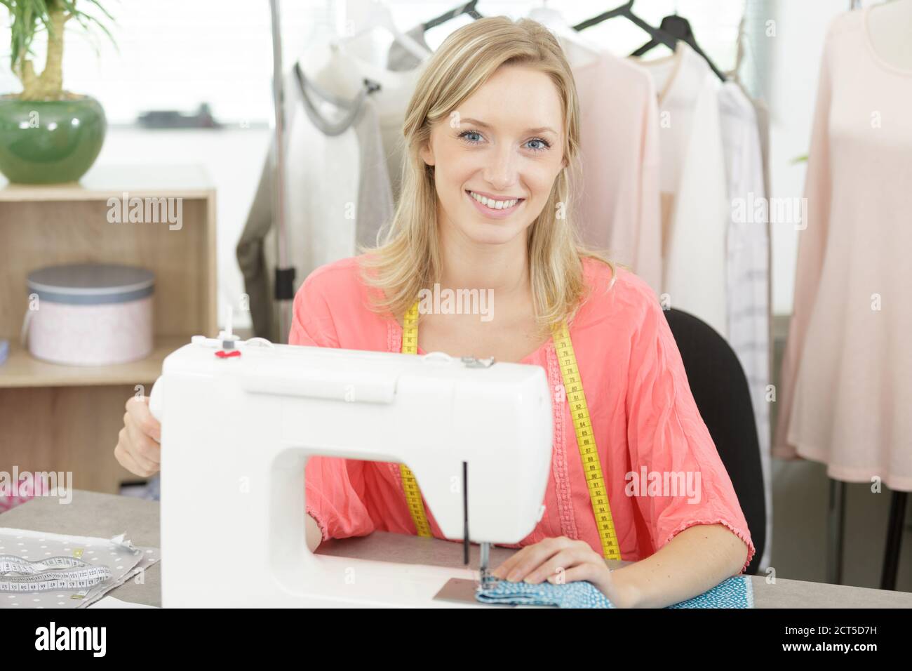 beautiful smiling tailor enjoying work on sewing machine Stock Photo ...