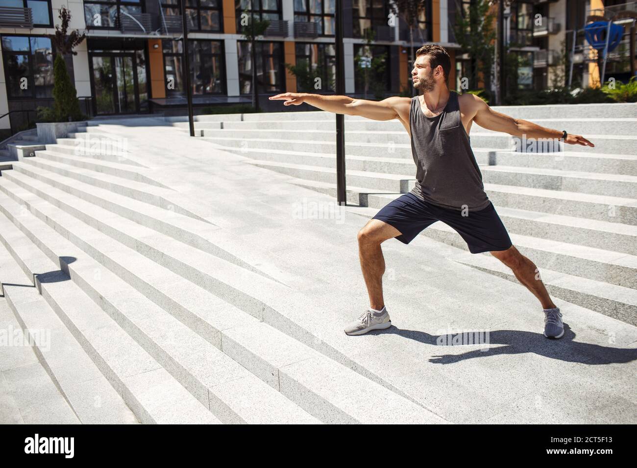 Young man exercising outside. Guy standing in yoga position alone at ...