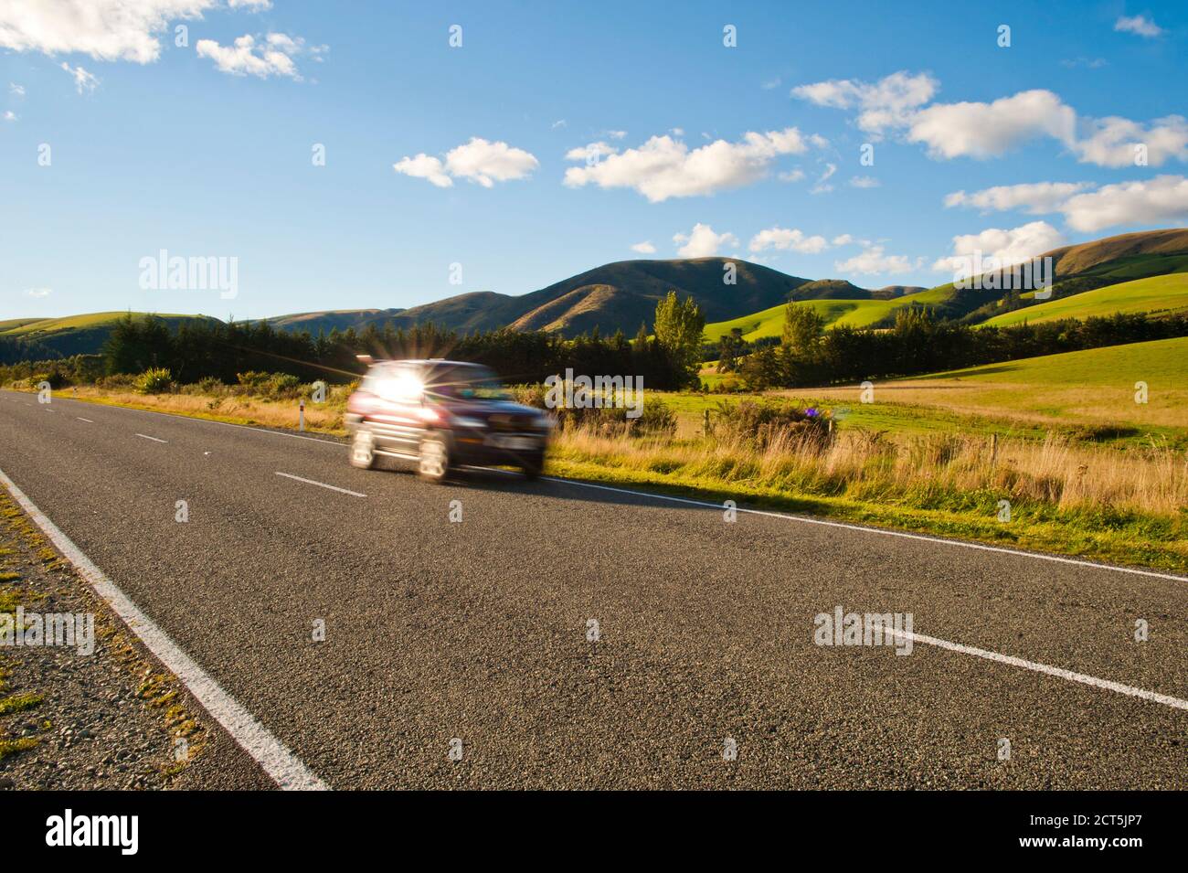 Car Speeding Along a Road in South Island New Zealand Stock Photo