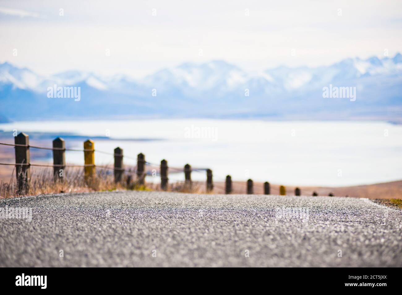 Close up detail of mountain road with snow capped mountains and lake landscape at Tekapo, South Island New Zealand Stock Photo