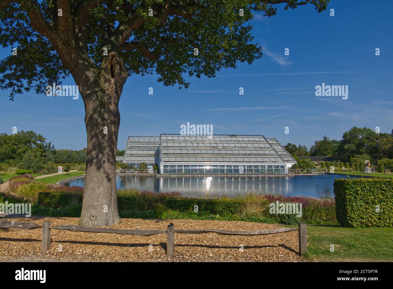 The Glasshouse reflected in the lake at RHS Garden, Wisley, Surrey, UK Stock Photo