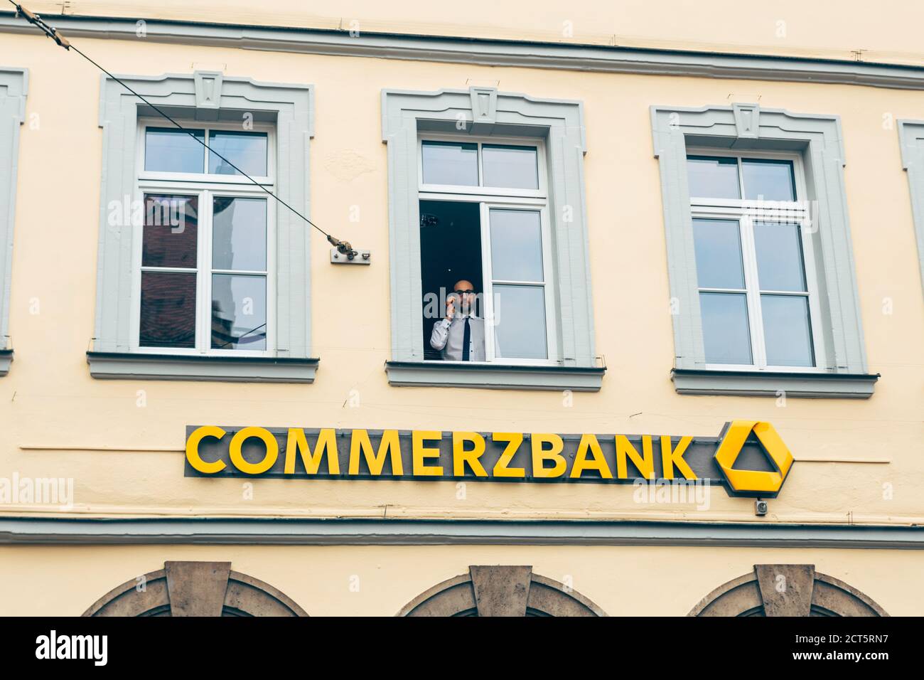 Wurzburg/Germany-3/1/19: a manager is looking out of the window of the Commerzbank on Beim Grafeneckart in Wurzburg. Commerzbank AG is a major German Stock Photo