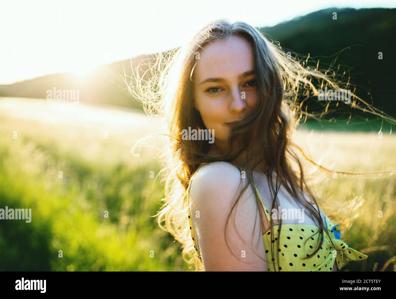 Portrait of young teenager girl outdoors in nature at sunset. Stock Photo