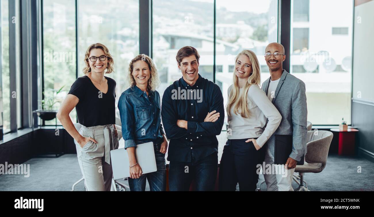 Portrait of a multi-ethnic business team smiling together in office ...