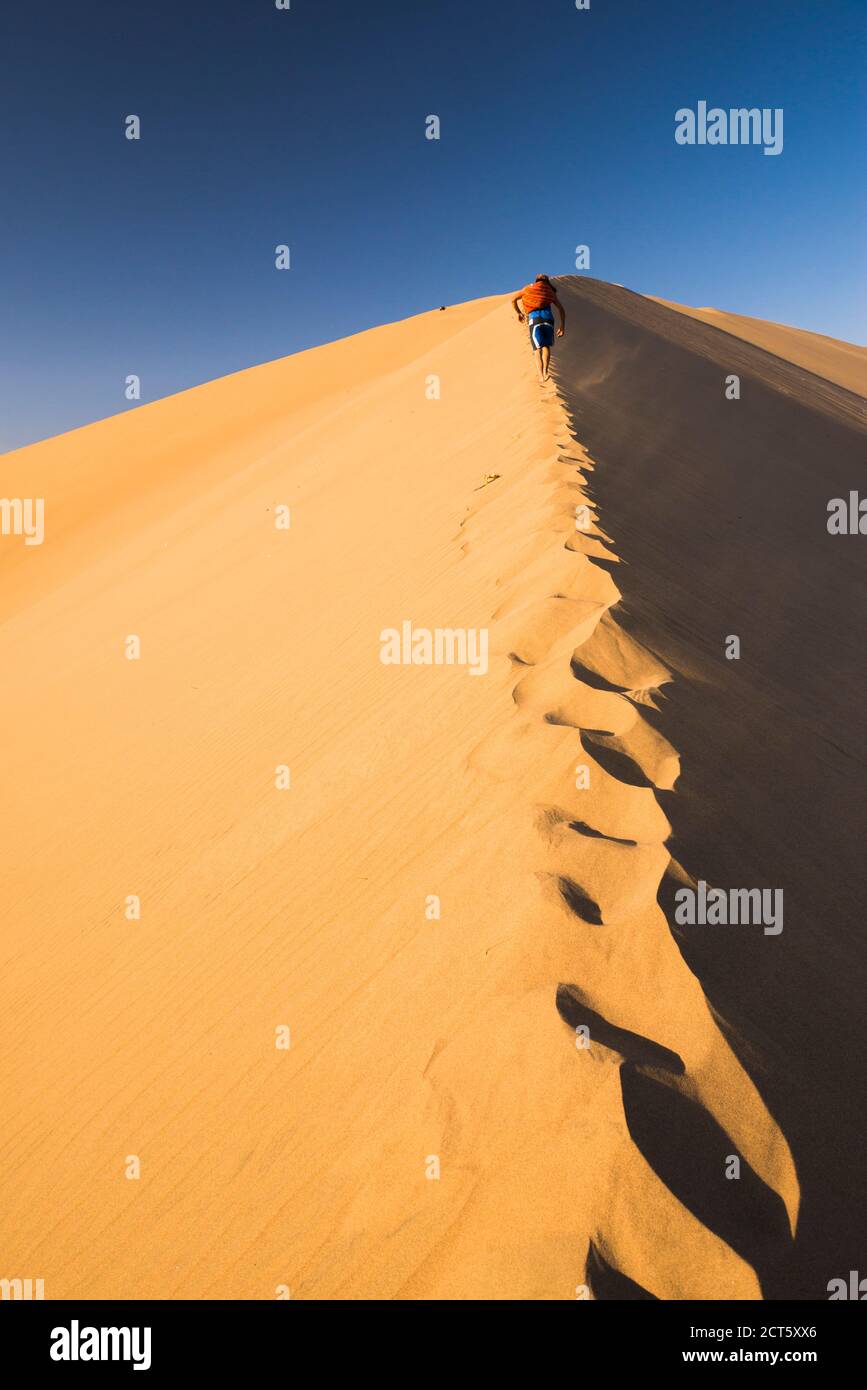 Tourists climbing sand dunes at sunset at Huacachina, a village in the desert, Ica Region, Peru, South America Stock Photo