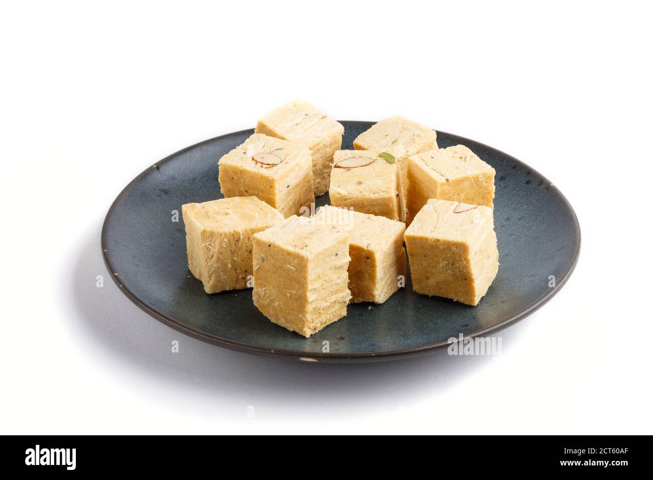 traditional indian candy soan papdi in blue ceramic plate isolated on a white background. side view, close up. Stock Photo