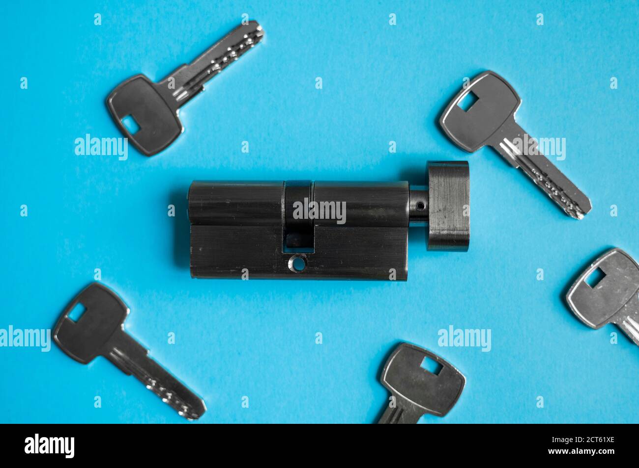 A door lock cylinder core with keys on the blue background. The