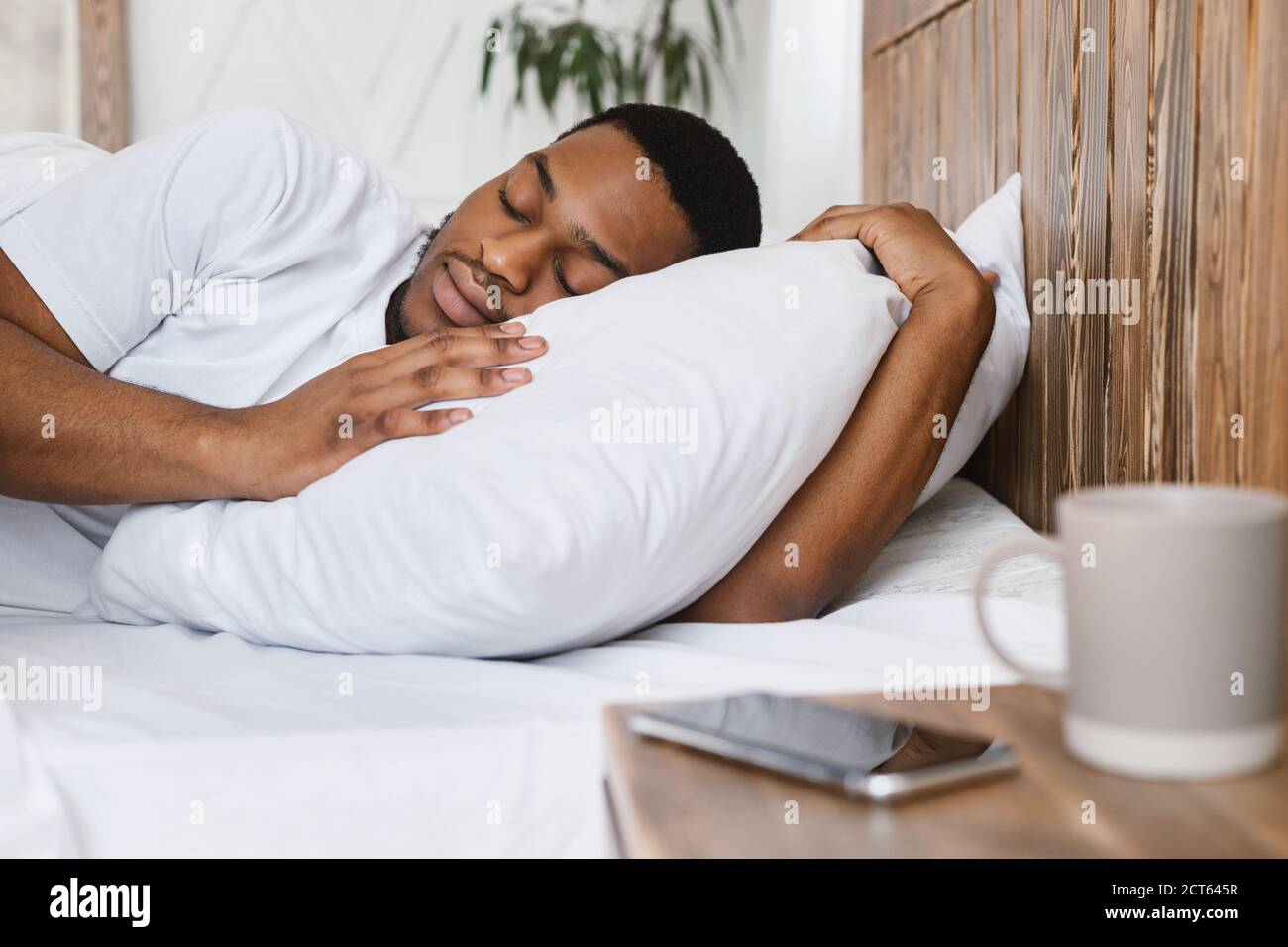 African Guy Sleeping Through AlarmClock Lying In Bed At Home Stock