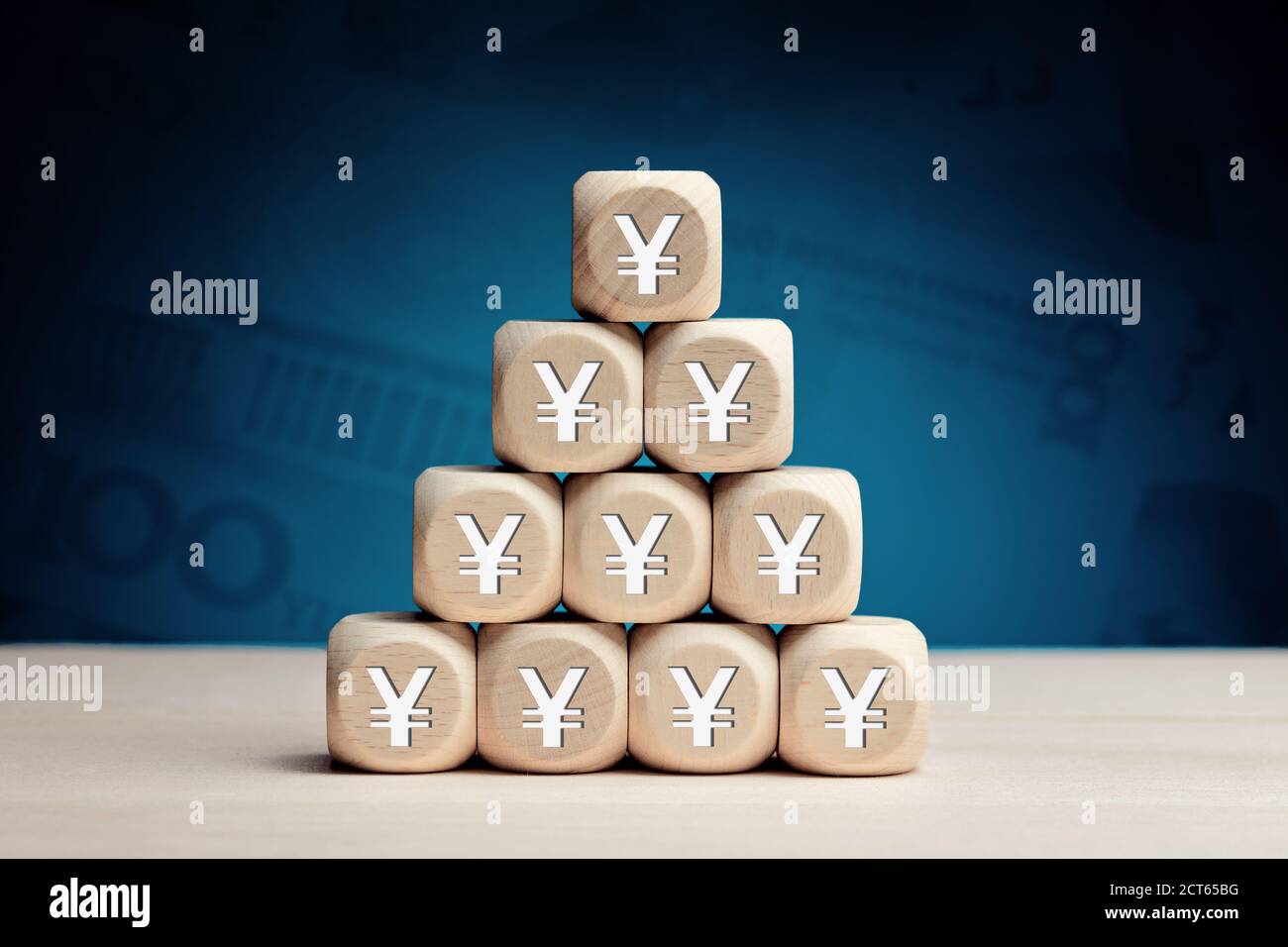Chinese yuan or japanese yen symbol on wooden cubes against money background. Financial reserves, growth, profit, investment or savings in business co Stock Photo