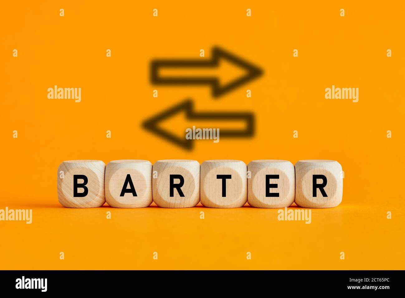 The word barter written on wooden cubes with exchange icons on yellow background. Trade in business market concept. Stock Photo
