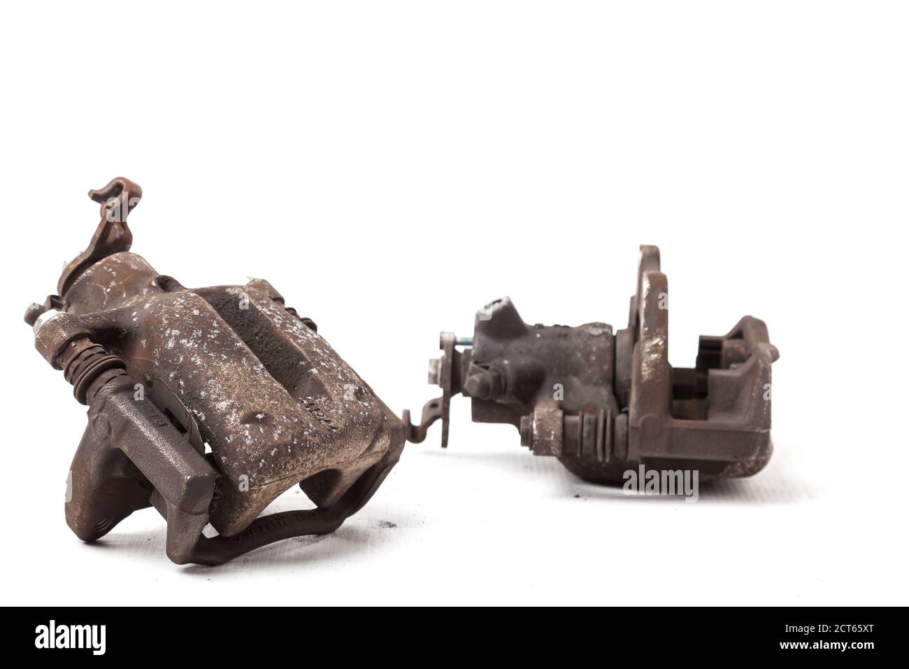 Close up old, worn out and rusty car caliper of brake system on white