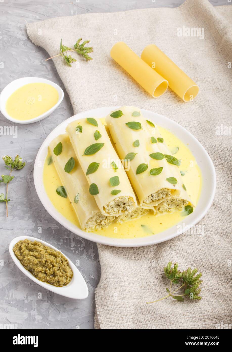 Cannelloni pasta with egg sauce, cream cheese and oregano leaves isolated  on white background. side view, close up Stock Photo - Alamy