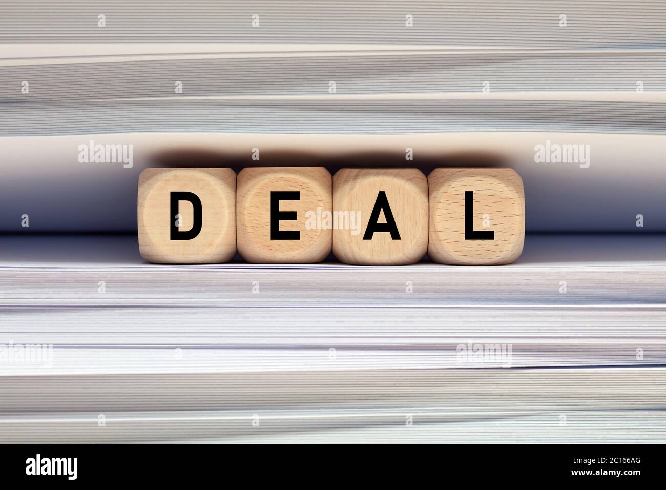 The word deal on wood cubes with file folder document background. Making a deal contract and paperwork in business concept. Stock Photo