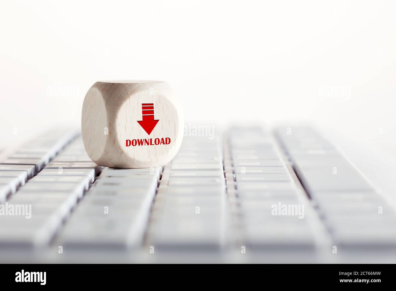 The word download with arrow icon on wooden cube with computer keyboard. Data downloading concept. Stock Photo
