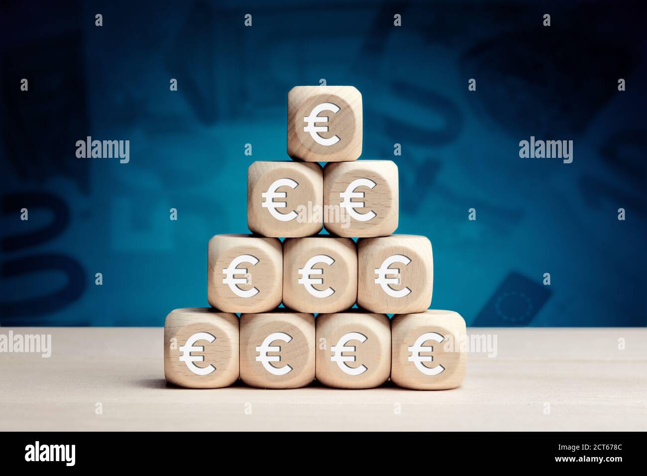 Euro symbol on wooden cubes against money background. Financial reserves, growth, profit, investment or savings concept. Stock Photo